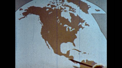 1960s: Hand points to map of United States. Man talking in front of map, walks to side. Hand points to map.
