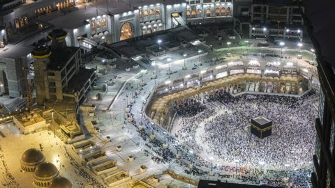 Time lapse sunset of Muslim pilgrims circling around the holy Kaaba at day and praying inside al Masjid al Haram in Mecca, Saudi Arabia. Zoom in motion. Prores 4K.