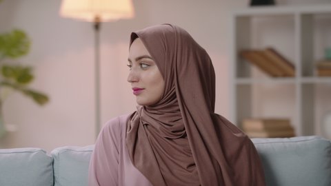 Young beautiful authentic positive arab woman wearing traditional head scarf brightly smiling, successful millenial businesswoman expressing positive emotions on office background 4k footage