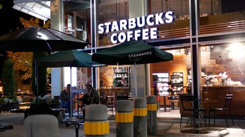 Coquitlam, BC, Canada - November 07, 2016 : People enjoying coffee inside Starbucks coffee at night with 4k resolution.