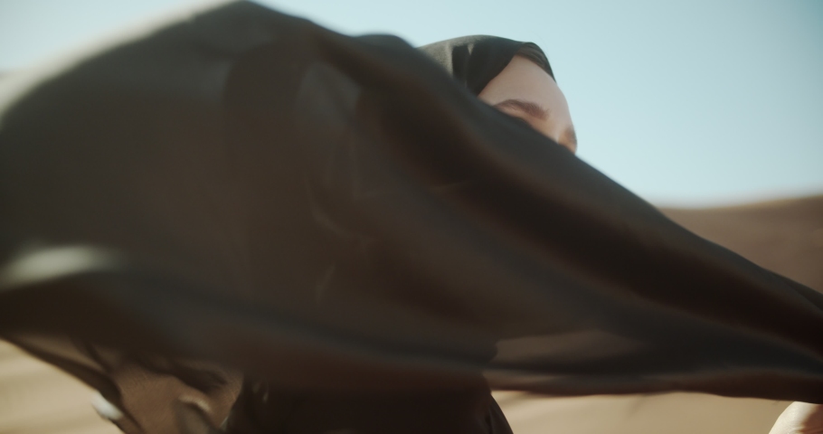 Close-up face of beautiful caucasian girl with her head covered in hijab and developing scarf. 4K Slow Motion Royalty-Free Stock Footage #1048546813