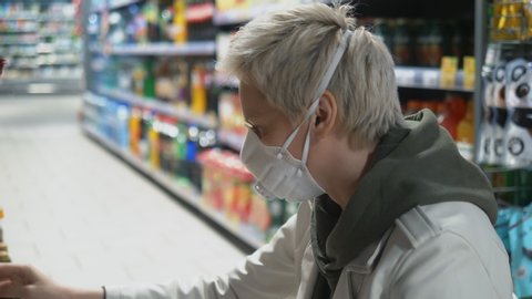 short haired blond woman in medical mask at the grocery store. pandemic. – Stockvideo