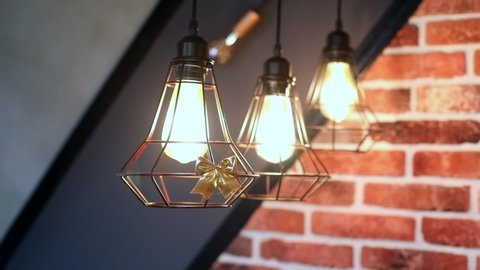 Close up of modern loft lamp lights with brick wall on background. Interior design. Beautiful home decoration. Traveling. Stylish room. Restaurant business. Lamps lighting. Eco friendly system