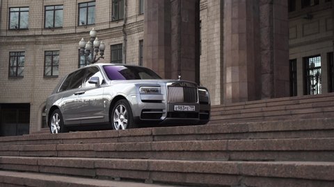 Moscow, Russia - 13 03 2020: The majestic Rolls Royce Cullinan in his path. expensive car drove up to the palace with huge columns and stands waiting for the businessman.