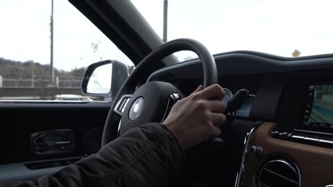Moscow, Russia - 13 03 2020: A man drives Rolls Royce Culinan. View of hands on steering wheel.