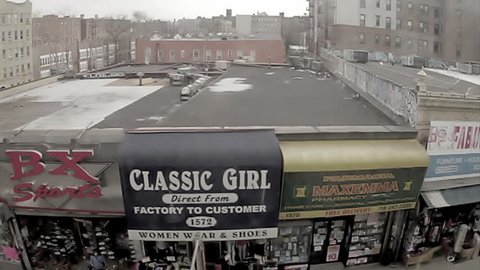NEW YORK - FEB 9, 2010: classic South Bronx stores and streets, elevated subway train view of ghetto in 70s style vintage 16mm footage, NY. Bronx is the northernmost borough in NYC.