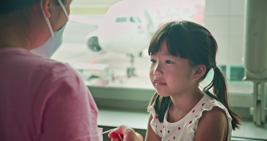 Asian parents wear masks to their children because of transmissible infectious diseases indoor in the airport Royalty-Free Stock Footage #1048606132