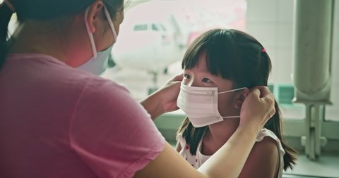Asian parents wear masks to their children because of transmissible infectious diseases indoor in the airport