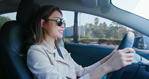 asian relaxed woman is driving electric car