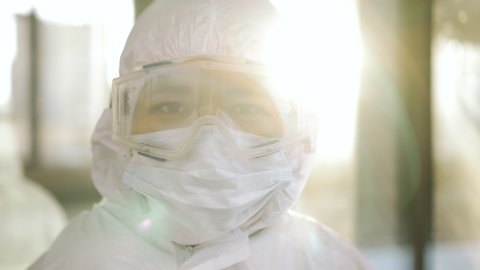 Portrait of epidemiologist protecting patients from coronavirus COVID-19 in mask. Global pandemic epidemic, Europe, Italy, USA. Doctor virologist working in suit, glasses. Appearance from blur