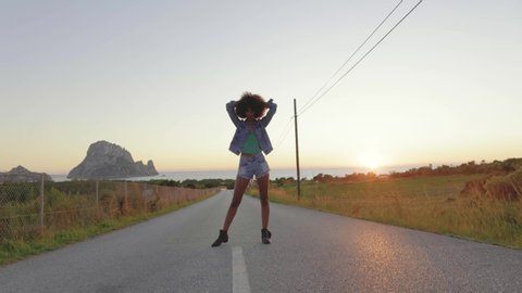 Young woman posing on road at sunset