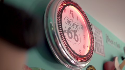 An old red vintage retro clock with route 66 hanging on the wall.