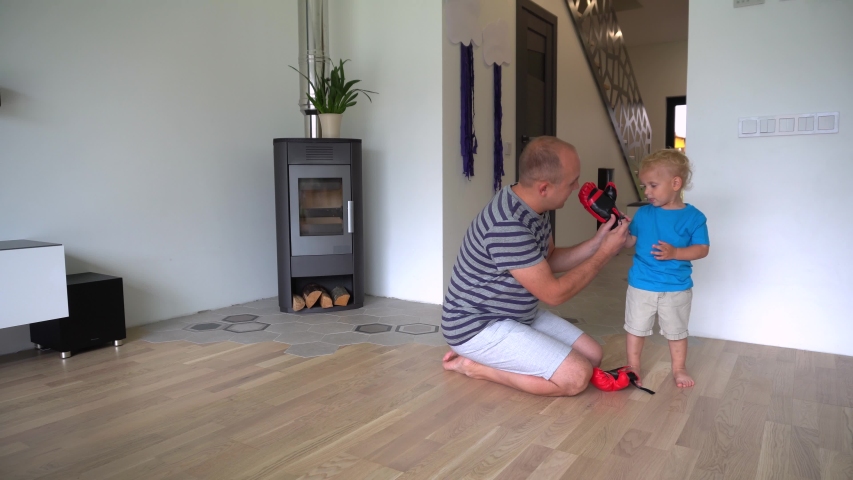 man helping his son to put on boxing gloves. Gimbal stabilizer movement motion shot