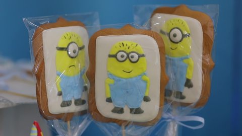 Kyiv, Ukraine - 10 02 2019: Sweet cookies on children birthday cake gingerbread minions on children happy birthday party yellow blue color candy bar closeup detail