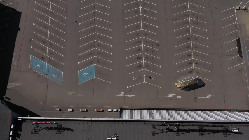Aerial drone shot of the empty parking lot of a supermarket due to Corona virus pandemic | Shutterstock HD Video #1048637626