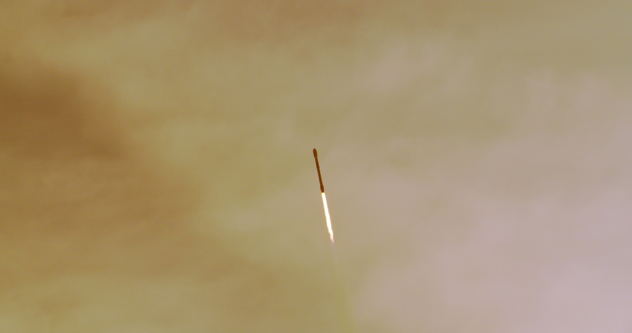 Space Rocket Rocket blasts off into the sky at sunrise from Kennedy Space Center as it climbs through dramatic clouds. Flames and exhaust trail behind the spacecraft. Royalty-Free Stock Footage #1048637851