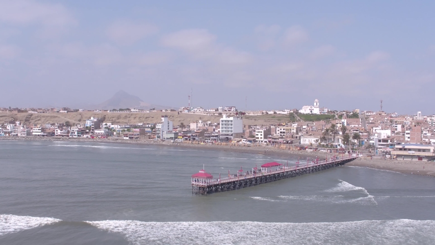 Left traveling aerial drone view move of Huanchaco Beach in Trujillo city at a sunny day in La Libertad Region, Peru