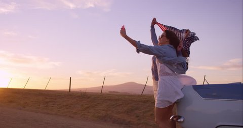 beautiful Girl friends taking selfies on road trip at sunset with vintage car RED DRAGON