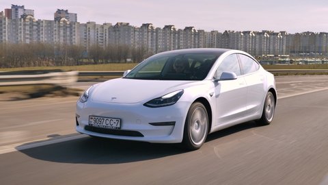 MINSK, BELARUS - MARCH 20, 2020: Tesla Model 3 Performance drives on a highway. It has dual motor all-wheel drive, total output is 451 hp. Model 3 is the best-selling plug-in electric vehicle.