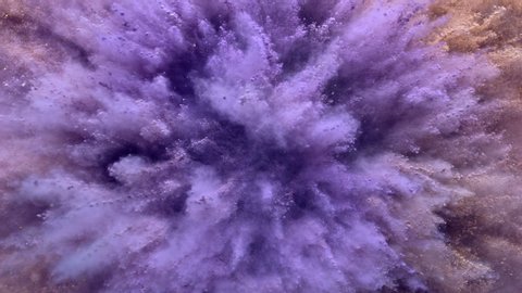 A surface filled with purple colored powder surrounded by beige dust blasting towards camera and making smoky texture in close up and super slow motion