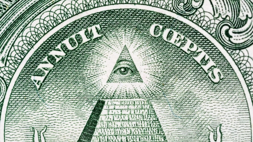 Creative 4k video of details of a 1 american dollar banknote macro closeup with a pyramid and the effect of a glowing mason eye on top. Pyramid close-up on a banknote of 1 US dollars.  Royalty-Free Stock Footage #1048667323