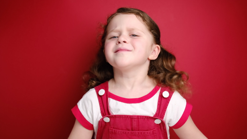 Relaxed little curly girl enjoying good smell or pleasant fragrance, serene mindful child taking deep breath feel no stress free inhaling fresh air relaxing isolated on red studio background Royalty-Free Stock Footage #1048680418