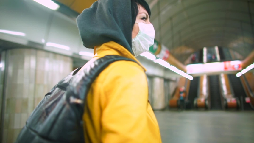A volunteer in a medical mask in the public transport station. Evacuation of tourists. Quarantine in Europe. Civil solidarity. Adaptation to life in self-isolation COVID-19, lockdown over Omicron wave Royalty-Free Stock Footage #1048686931