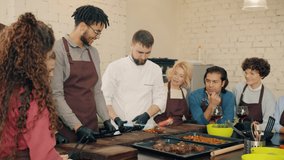 Slow motion of chef demonstrating food preparation with fire during master-class while students are watching and learning. People and culinary concept. - Powered by Shutterstock - Get 15% off with code: PIKWIZARD15