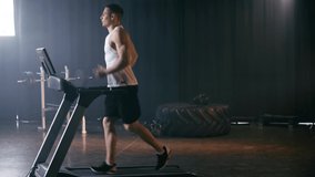 sportive man running on treadmill in sports center