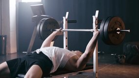 athletic sportsman weightlifting heavy barbell in gym