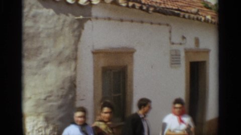 NAZARE PORTUGAL-1965: A European Family Standing In The Sunlight Waiting On Someone