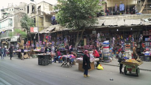 CAIRO, EGYPT - CIRCA 2020: Car traffic and typical open street market in central Cairo, panning video