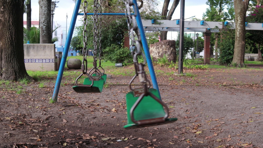 Swings in a lonely park moving go and forward