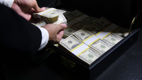 Stacks of 100 dollar bills in a briefcase , briefcase full of money .