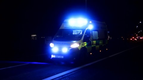 UK Ambulance vehicle responding to corona virus emergency, siren and blue flashing lights. Driving down busy road.  Filmed Kingston upon Hull city centre 20/03/2020