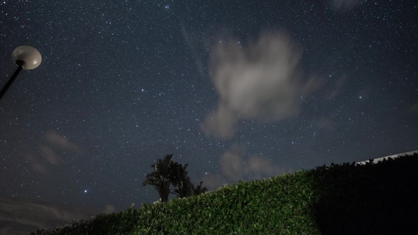 A lot of stars in the night sky with clouds coming in.