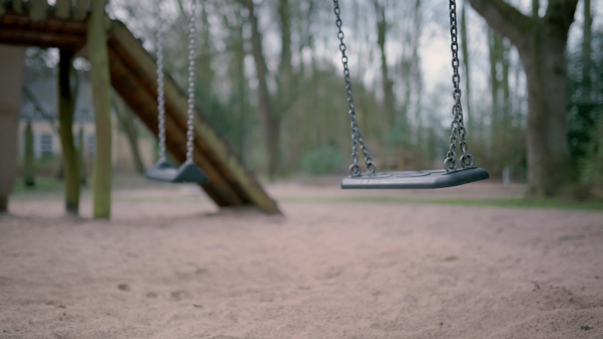 Empty swing on children playground during state of emergency by the reason of covid-19 virus threat Royalty-Free Stock Footage #1048753363