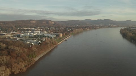 Cinematic drone / aerial shot of the river rhine with the Siebengebirge seven mountains and the Kameha Grand Hotel Bonn Königswinter at golden hour afternoon, 24p