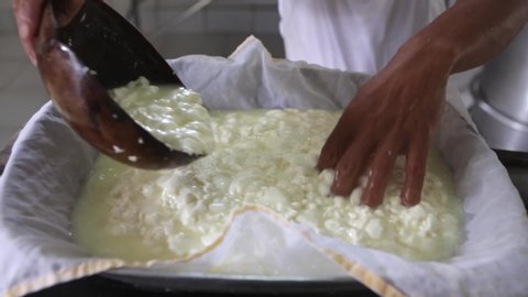 Close up of man's hand straining rennet milk to make the famous artisan cured cheese from Minas Gerais on white cotton cloth. Concept of gourmet, food, cook, healthy, organic, protein, fat and eat.