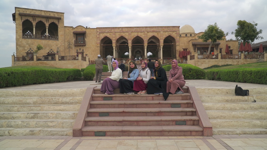 CAIRO, EGYPT - CIRCA 2020: Photographer taking photos of young Arabian women in the Al-Azhar Park, a large public park and urban oasis in central Cairo