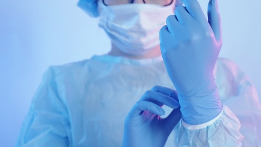 Coronavirus protection. Healthcare service. Female doctor in face mask wearing gloves. Royalty-Free Stock Footage #1048777804
