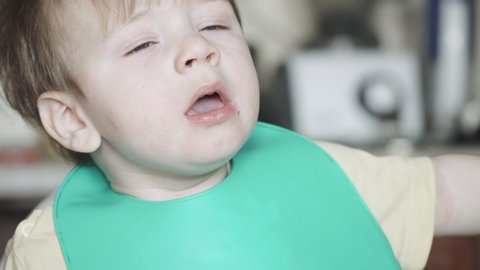 Boy sneezes in a child seat and eats hematogen