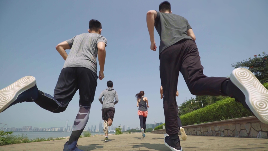 Rear view of five asian young adults running in seaside park | Shutterstock HD Video #1048795948