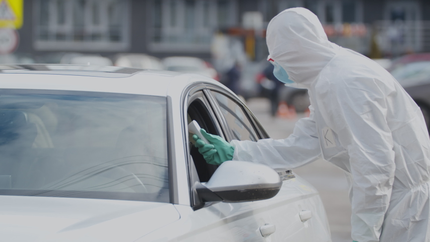 Stop coronavirus. Remote measurement of temperature of traveler coming from abroad by car and disinfection of auto on the border. Virologists work at border of countries Royalty-Free Stock Footage #1048795969