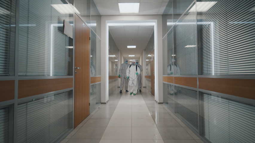 Fighting covid-2019 three men in protective suits carrying equipment and examining building after disinfection against coronavirus. Specislists disinfecting empty office during coronavirus quarantine | Shutterstock HD Video #1048795978