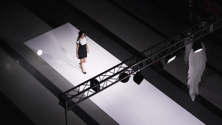 Fashion design female clothes woman on podium slow motion spotlights scene. Defile beautiful girl in colorful dress on catwalk model show close up evening vogue 4K. Royalty-Free Stock Footage #1048803067