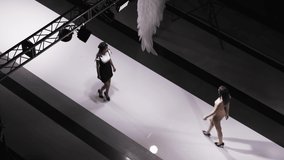Fashion design female clothes woman on podium slow motion spotlights scene. Defile beautiful girl in colorful dress on catwalk model show close up evening vogue 4K. - Powered by Shutterstock - Get 15% off with code: PIKWIZARD15