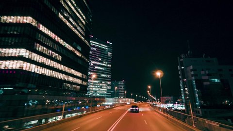 Bucharest, Romania - 02.20.2020: Crane rolling shot of a BMW 7 Series luxury sedan car driving on a city bridge at night 
