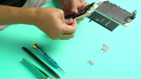 Chiang Rai, Thailand: March 11, 2020 - Technician or engineer disassembling smartphone and replace new smartphone battery for dead battery smartphone