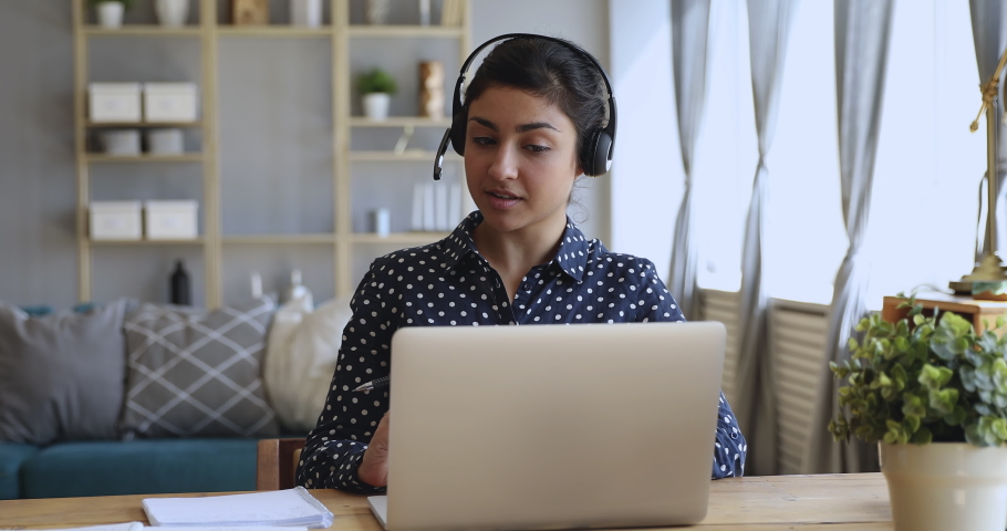 Focused millennial hindu professional financial advisor wearing headset, holding video call support services with customer. Motivated concentrated young indian student studying on online courses. Royalty-Free Stock Footage #1048820536